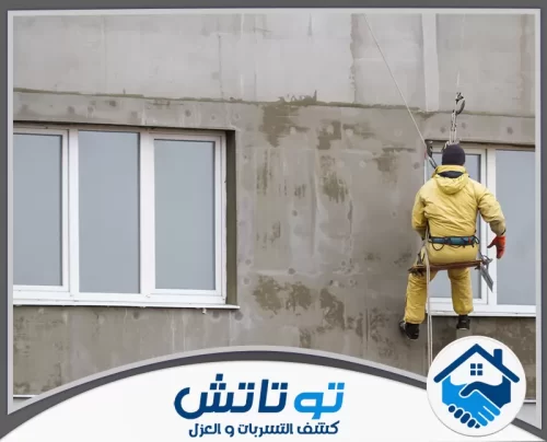 تكسير وترميم حمامات في عجمان 0565603382 شركة توتاتش هيكل معدني يحيط بمبنى شاهق، يظهر مراحل متقدمة من تركيب واجهات الحجر والزينة المعمارية.