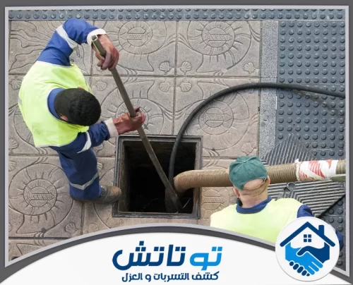 تسليك المجاري بالاسيد في ام القيوين 0565603382 شركة توتاتش لقطة علوية توضح عملية تسليك يدوية وشفط آلي لفتحة صرف صحي وسط رصيف مشاة مرصوف
