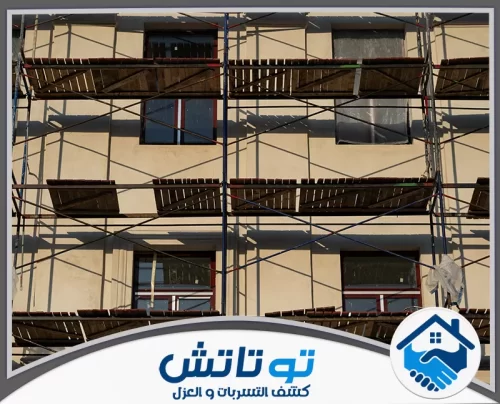 ترميم وتكسير مباني في العين 0565603382 شركة توتاتش واجهة مبنى حديث قيد الكساء، تحيط به السقالات المعدنية لاستكمال أعمال التشطيب الخارجي بدقة.