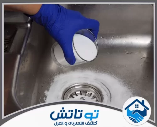 روائح التكييف والمكيفات غير النظيفة فى دبي 0565603382 شركة توتاتش شخص يرتدي قفازاً أزرق يسكب مسحوقاً أبيض للتنظيف داخل حوض معدني.